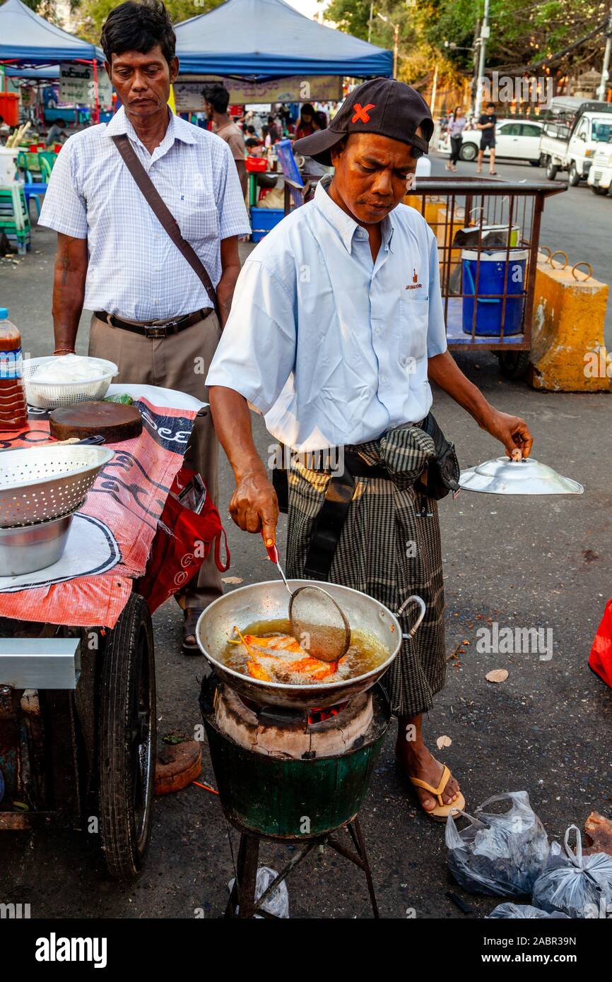A Man Cooking Food At A Street Food Stall In Downtown Yangon, Yangon, Myanmar. Stock Photo