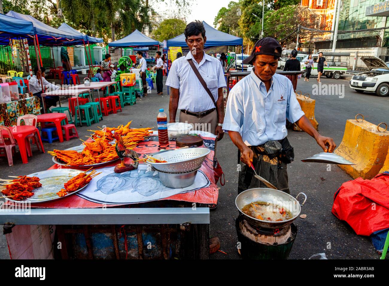 A Man Cooking Food At A Street Food Stall In Downtown Yangon, Yangon, Myanmar. Stock Photo