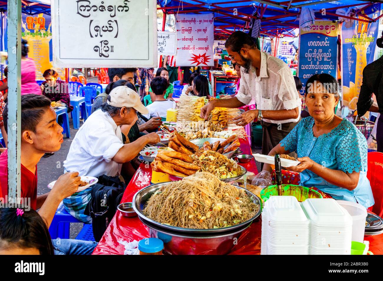 Local People Eating Street Food From A Street Food Stall, Yangon, Myanmar. Stock Photo