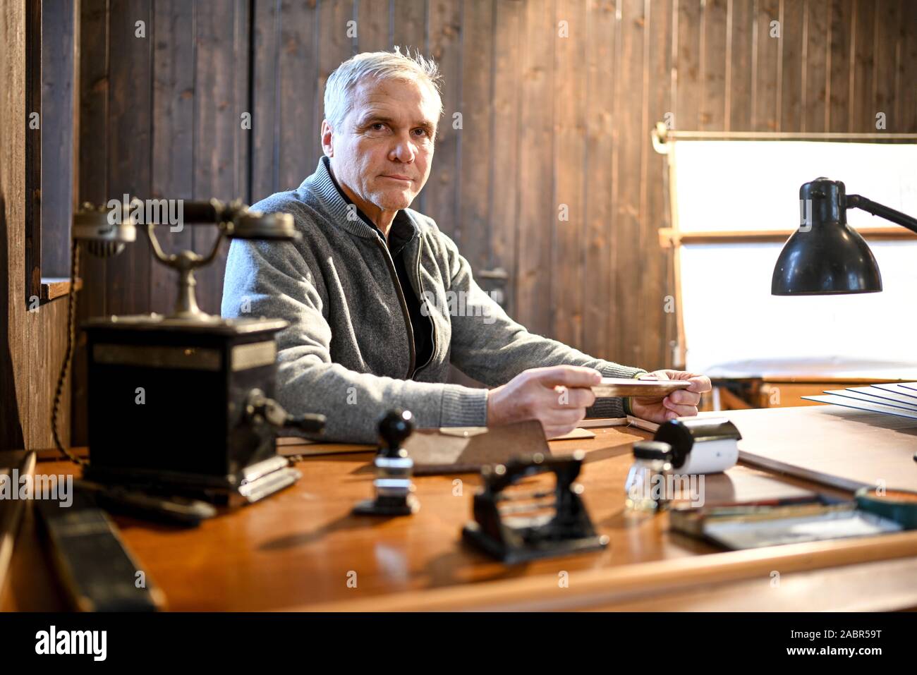 Friedrichshafen, Germany. 25th Nov, 2019. David Dornier sits in the former barrack where his grandfather, the aircraft designer Claude Dornier, worked at Lake Constance. The company history of aircraft designer Claude Dornier began in 1914 in the barrack in Seemoos in Friedrichshafen. (to dpa: 'Computer scientist wants to rebuild famous flying boat Do X - without plans') Credit: Felix Kästle/dpa/Alamy Live News Stock Photo