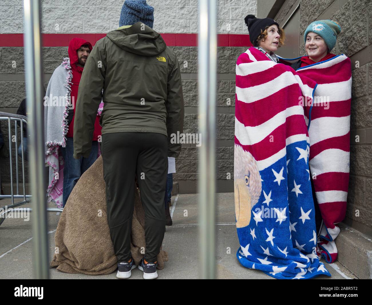 Ankeny Iowa USA. 28th Nov 2019. COURTNEY POUS OJEDA and her son XAVIER POUS OJEDA share a blanket to stay warm while they wait for the Target store in Ankeny Iowa top open. Black