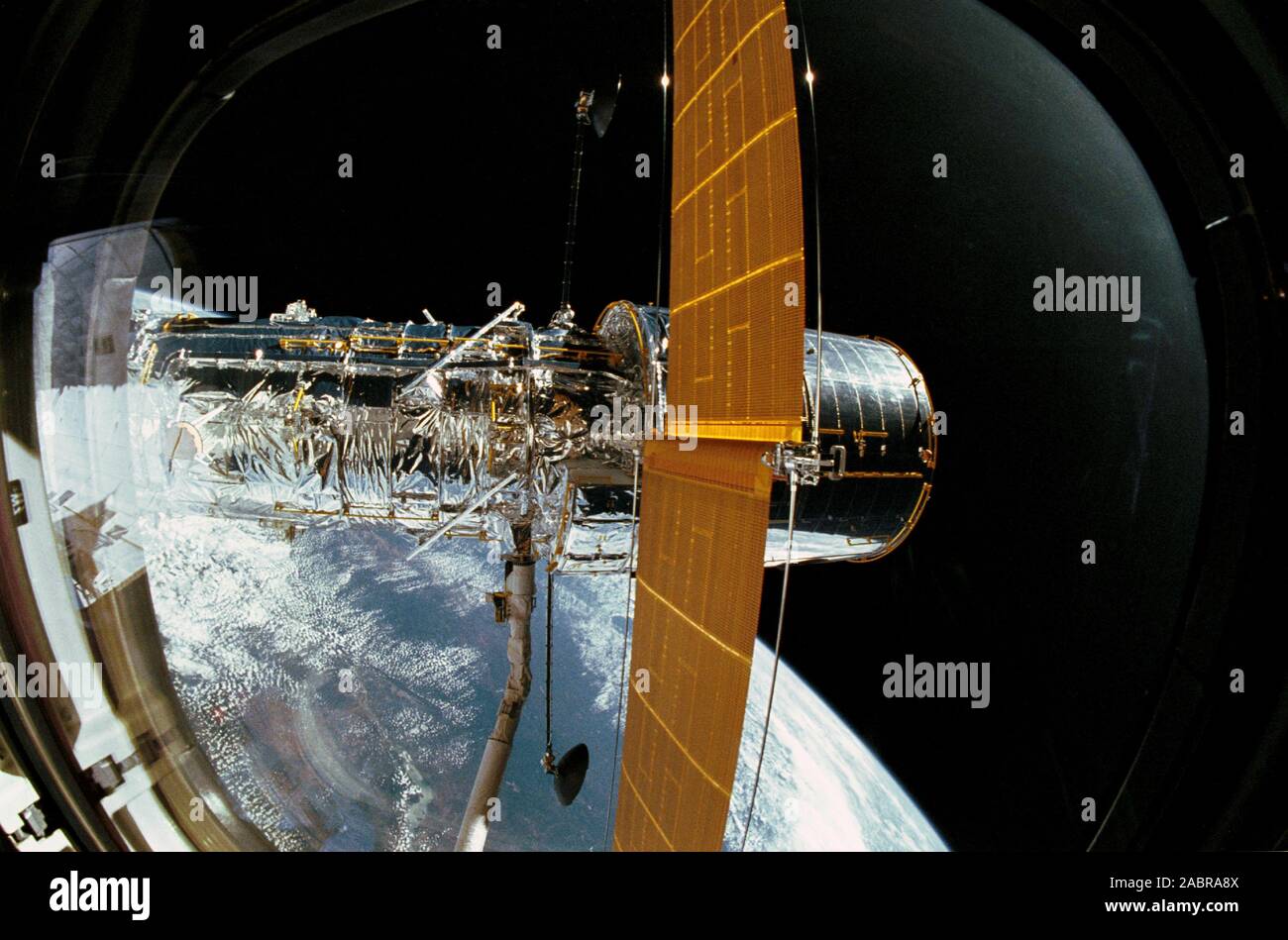 25 April 1990) --- The Hubble Space Telescope (HST), still in the grasp of  Discovery's Remote Manipulator System (RMS), is backdropped over Earth some  332 nautical miles below. In this scene, HST