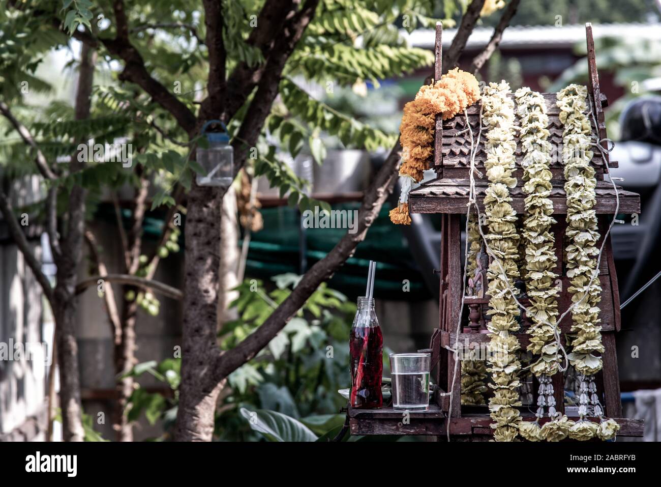 Spirit house and tree roots intertwined. Miniature house for guardian