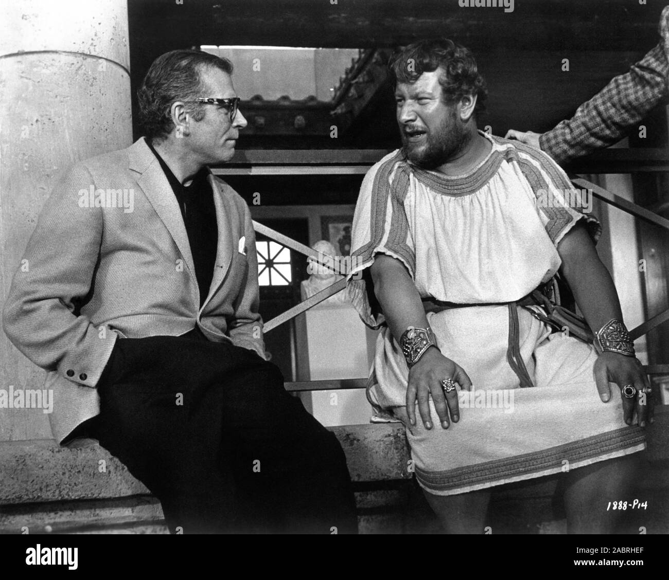 LAURENCE OLIVIER (out of costume) visits PETER USTINOV in costume as Batiatus on set candid during filming of SPARTACUS 1960 director STANLEY KUBRICK novel Howard Fast screenplay Dalton Trumbo executive producer Kirk Douglas Bryna Productions / Universal Pictures Stock Photo