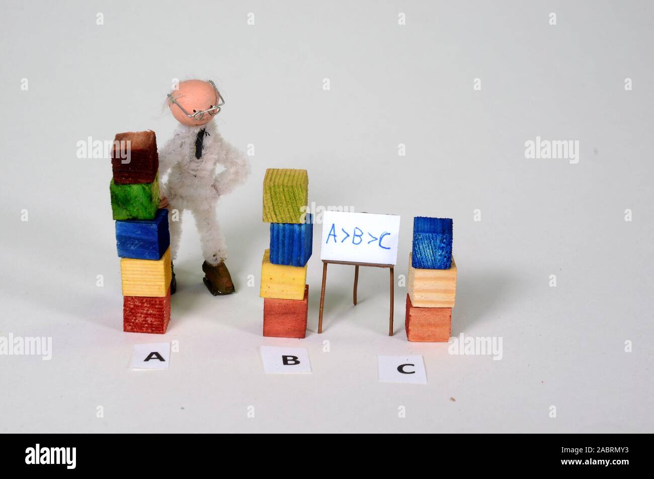 Mathematics setup with inequality:  A is larger than B that is larger than C, (interval) with the corresponding denotion on the blackboard. Stock Photo