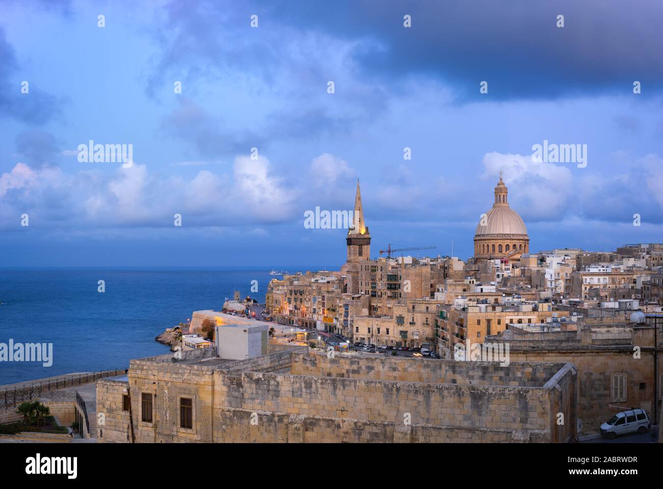 Skyline of Valletta at sunset with Basilica and St. Paul's Anglican Cathedral. Malta Stock Photo