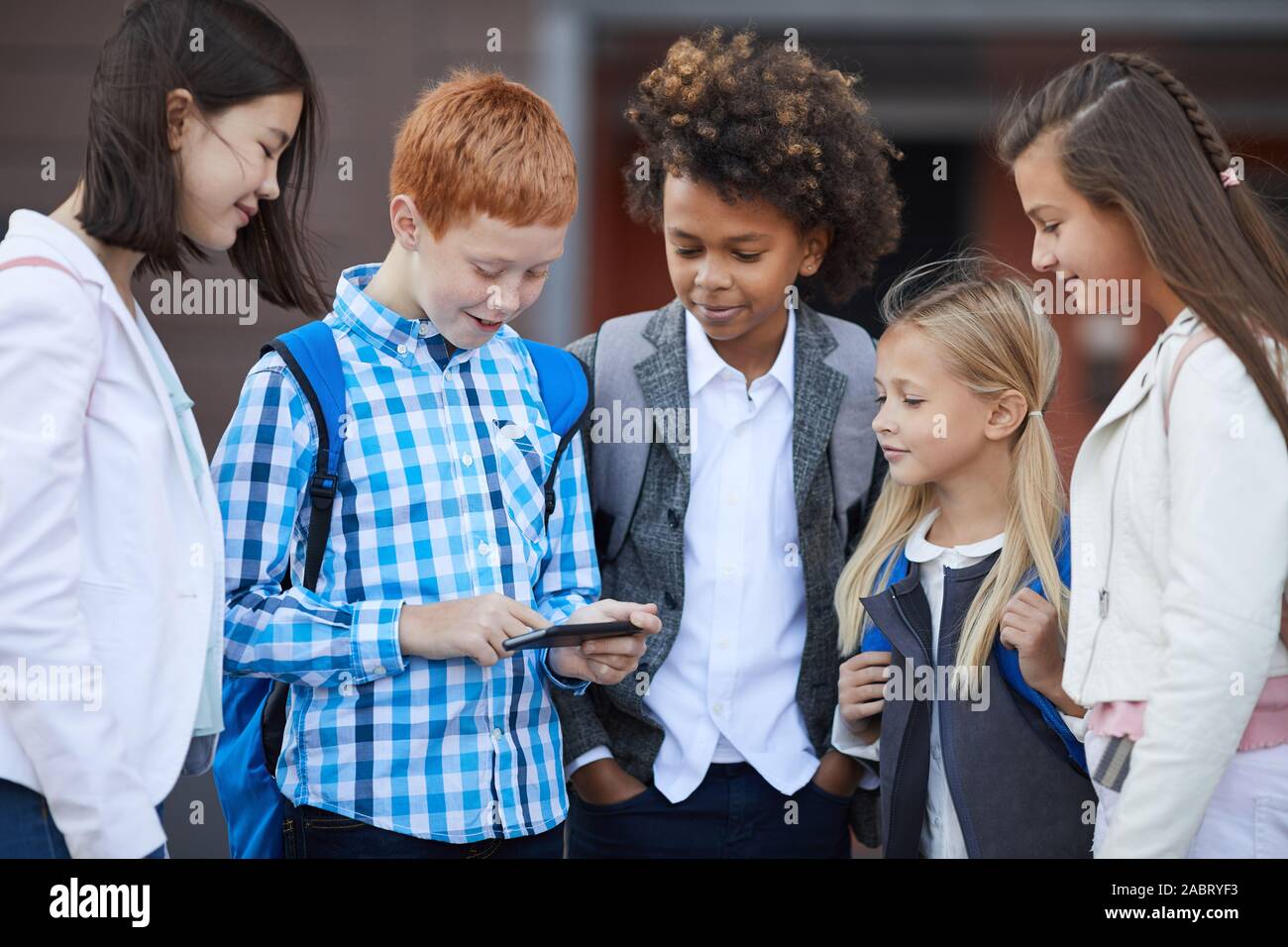 Group of multiethnic school children playing online games on mobile