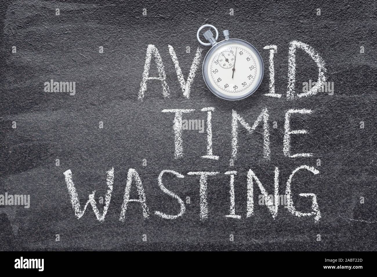 avoid time wasting phrase written on chalkboard with vintage precise stopwatch Stock Photo