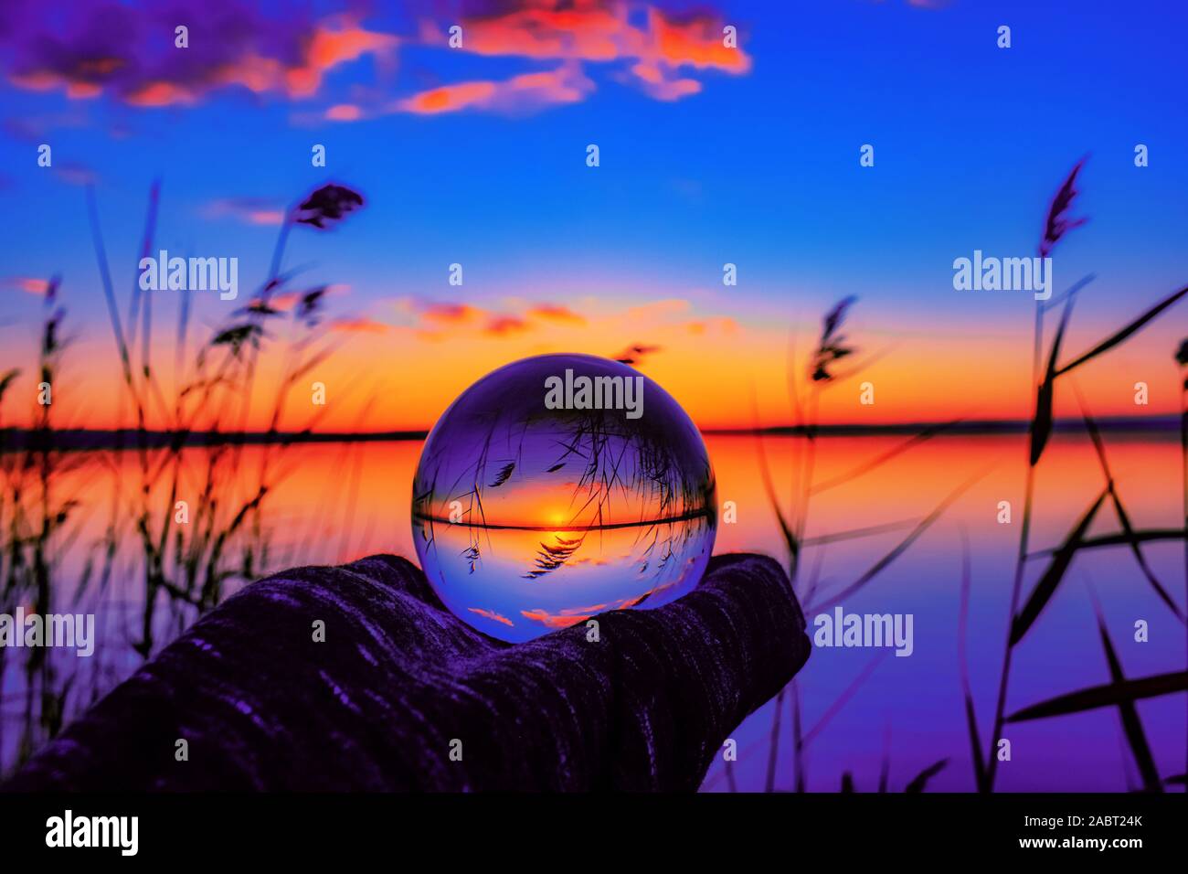 A beautiful selective focus shot of a crystal ball reflecting the breathtaking sunset with unique colors Stock Photo
