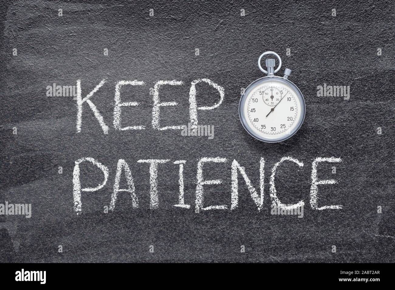 keep patience phrase written on chalkboard with vintage precise stopwatch Stock Photo