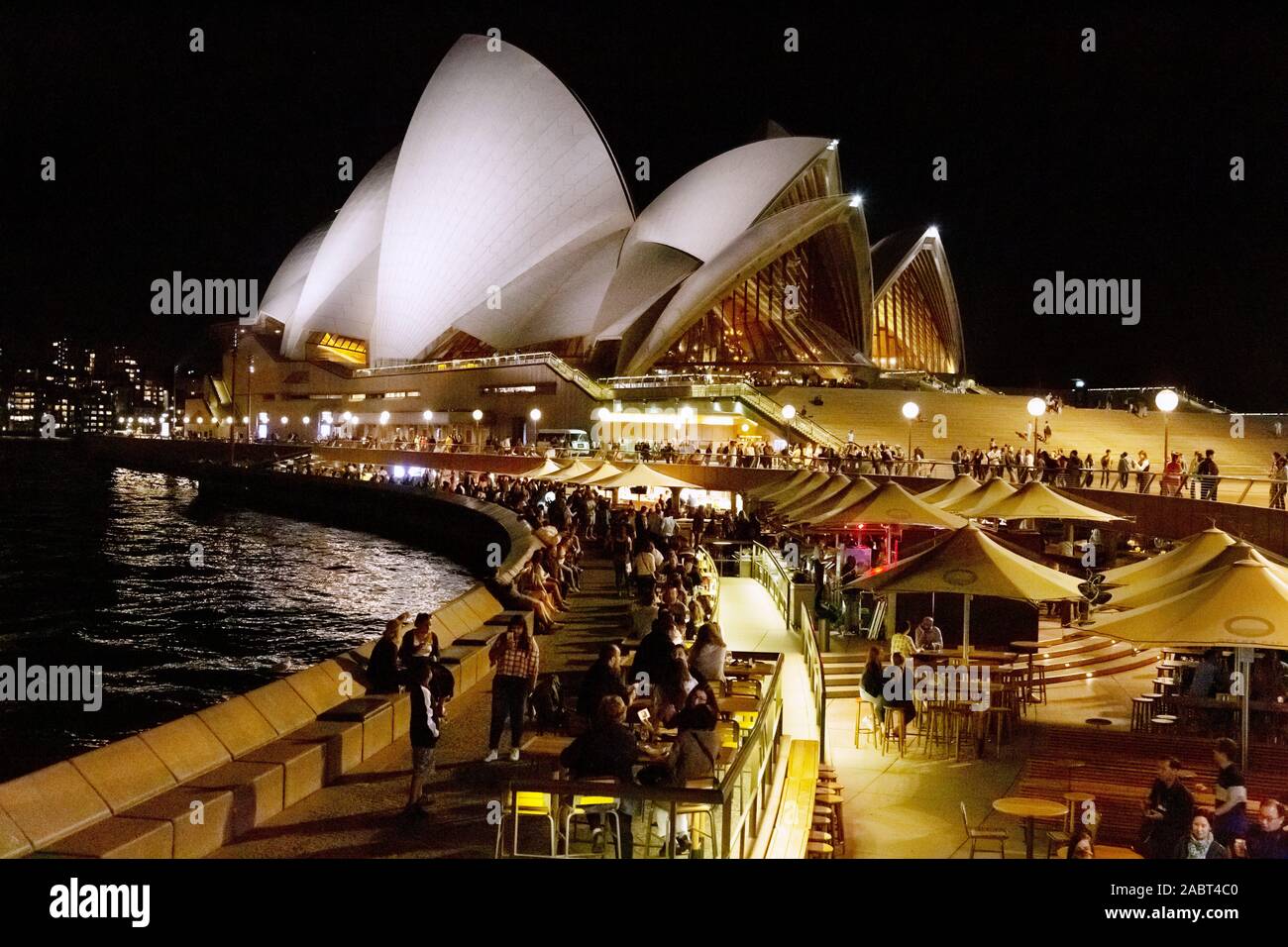 Sydney Opera House and sydney harbour at night - bars busy with people enjoying the nightlife; Sydney Australia Stock Photo