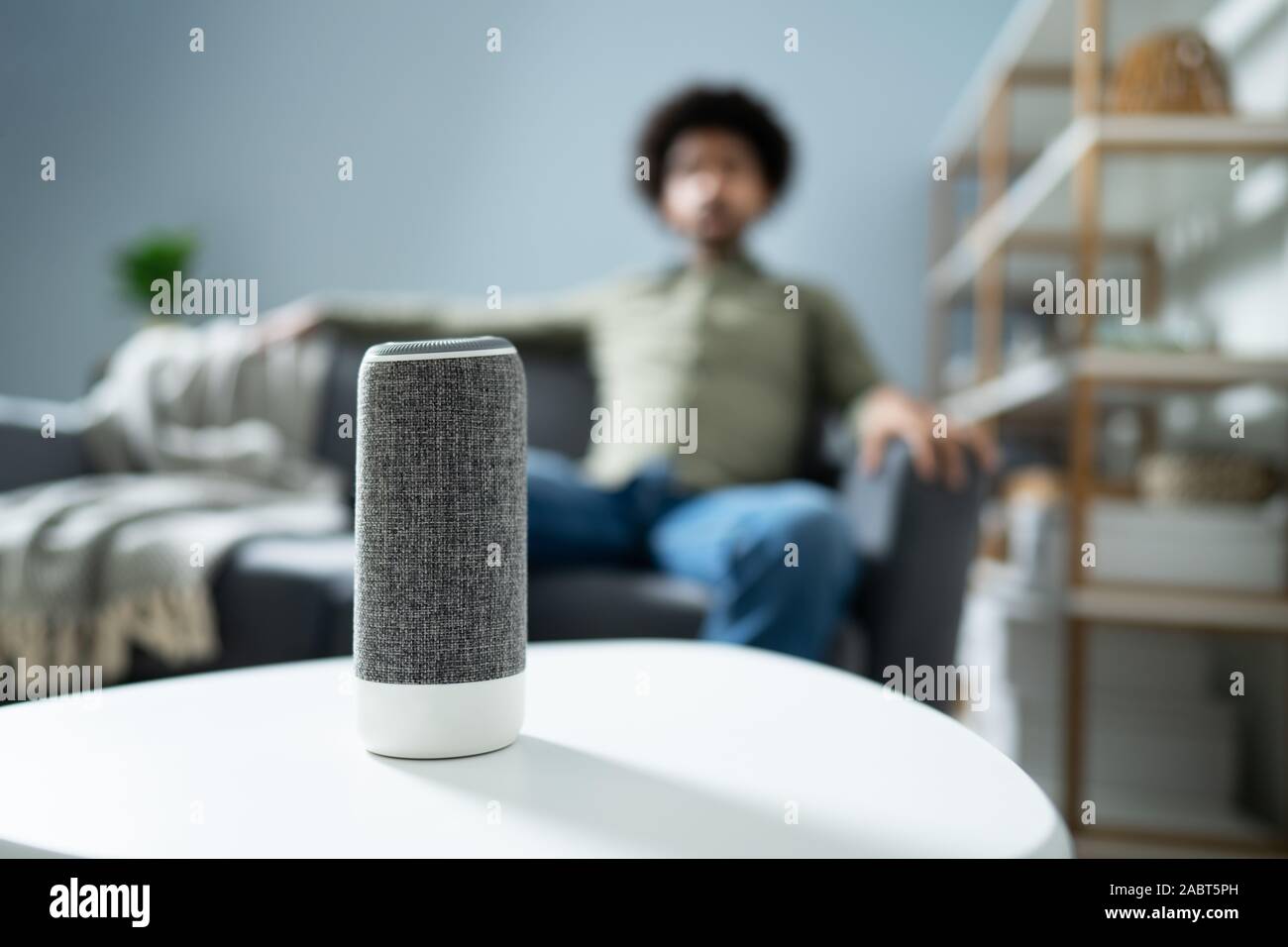 Young Man Using Wireless Speaker At Home Stock Photo