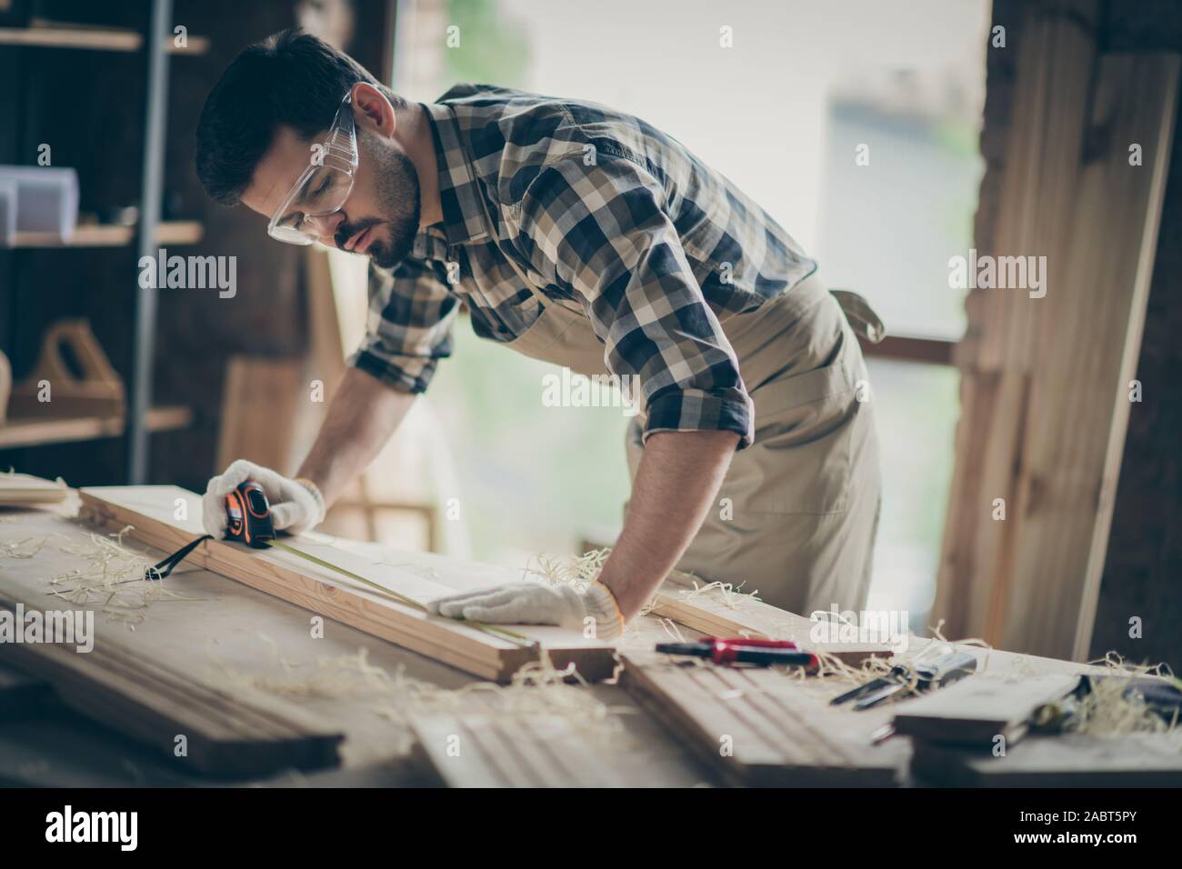 Portrait of his he nice attractive focused concentrated professional experienced guy specialist carving wood creating new furniture project at modern Stock Photo