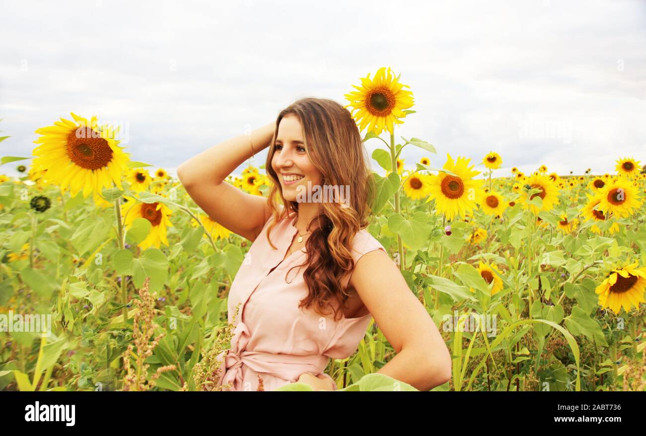 Beautiful woman in a sunflower field Stock Photo - Alamy