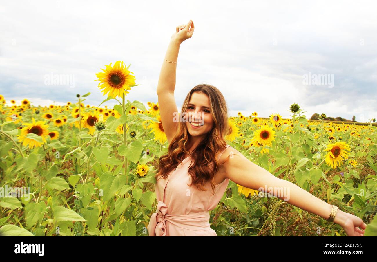 Beautiful woman in a sunflower field Stock Photo - Alamy