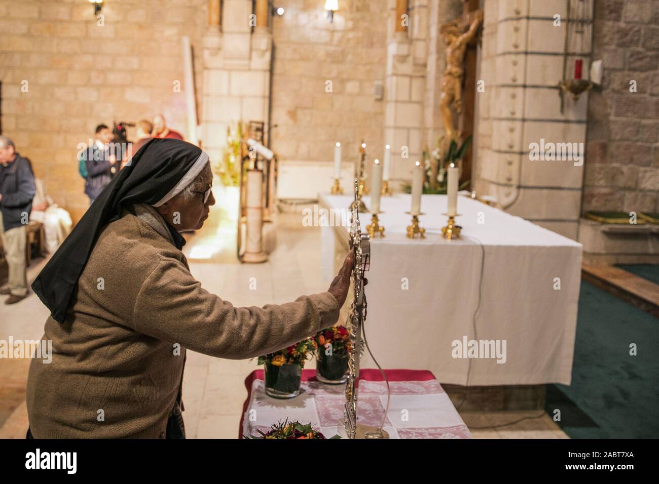 Jerusalem. 29th Nov, 2019. A nun touches a wooden fragment of a relic
