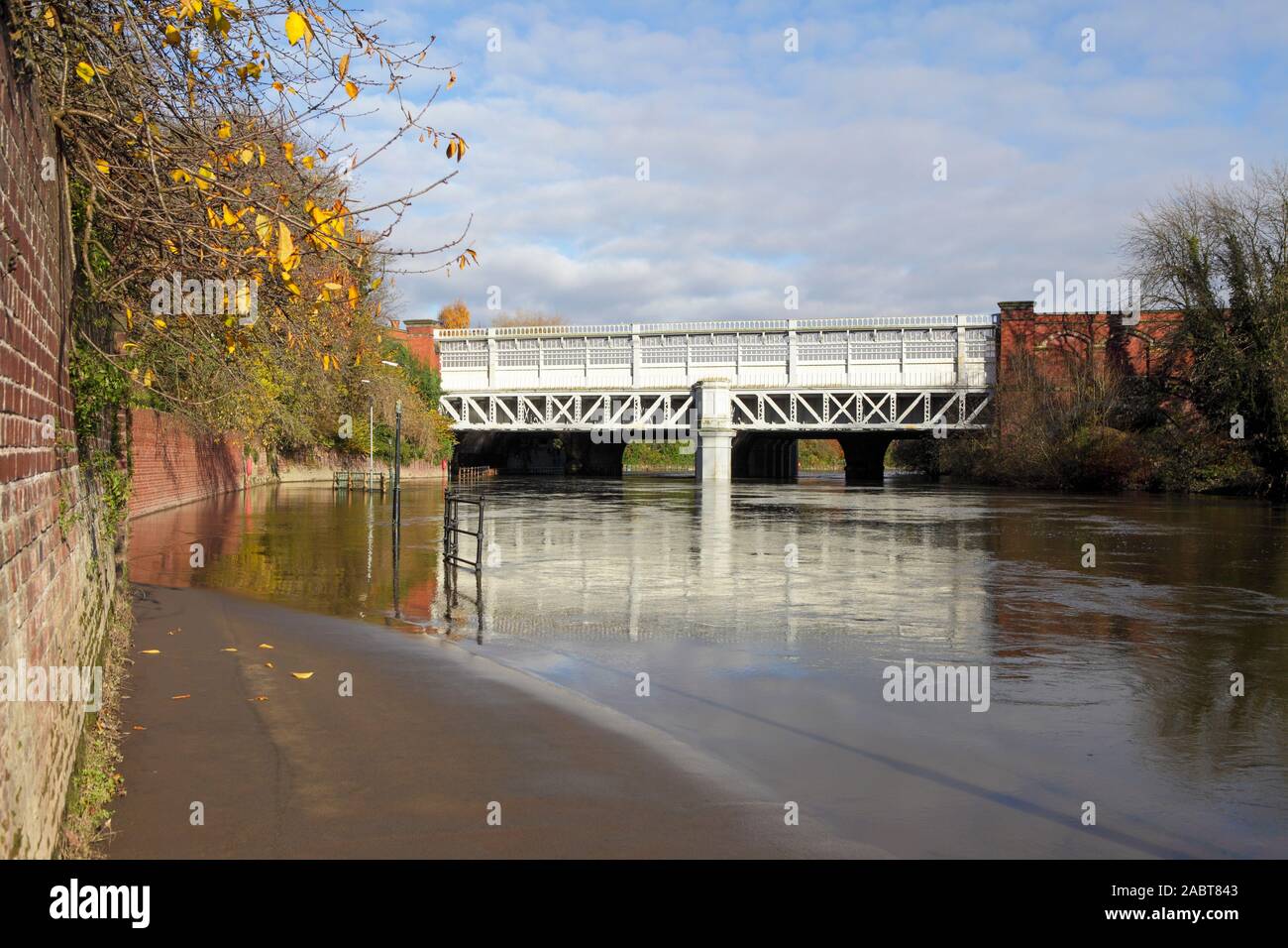 The Railway Bridge over the River Severn in Shrewsbury over what is a very swollen river indeed. The footpath is viewed here flooded. Stock Photo
