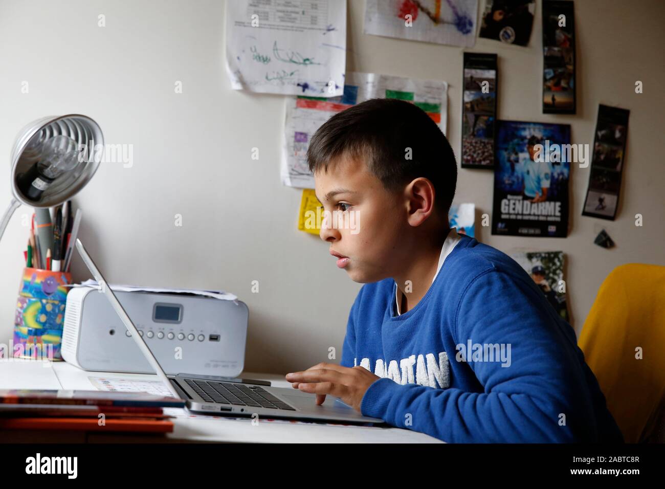 12 Year Old Boy Using A Laptop In His Bedroom In Montrouge