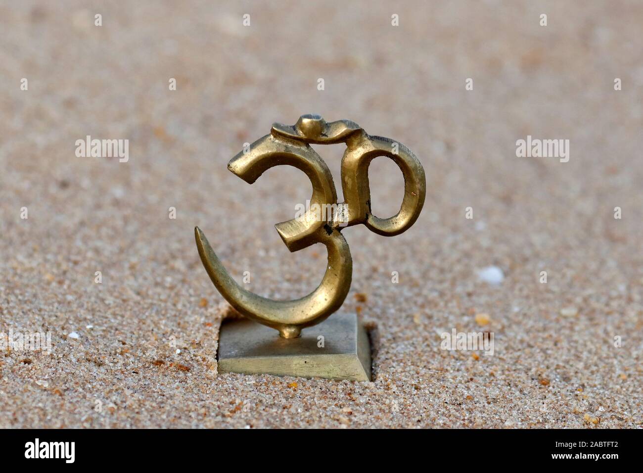 The Om or Aum symbol of Hinduism and Buddhism on the beach. Stock Photo