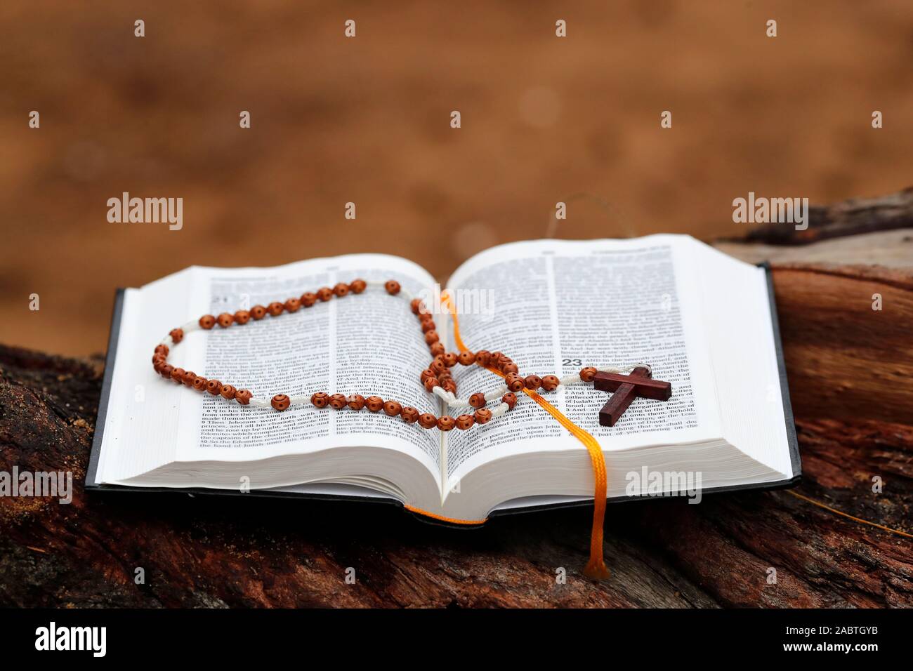 Wooden prayer beads and open Holy Bible on a trunk. Stock Photo