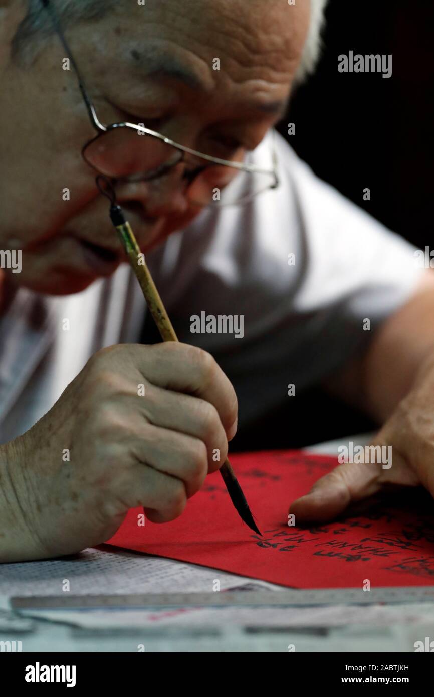 Old taoist monk writing prayers in chinese for the deads. Khanh Van Nam Vien Taoist pagoda.  Ho Chi Minh City. Vietnam. Stock Photo
