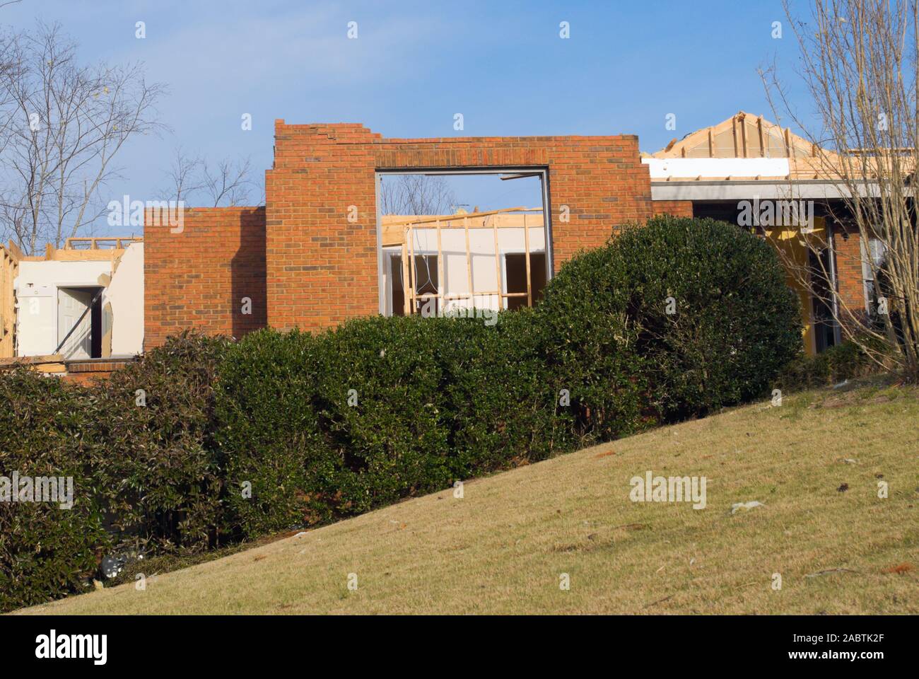 A brick house with no roof that has been destroyed by a springtime
