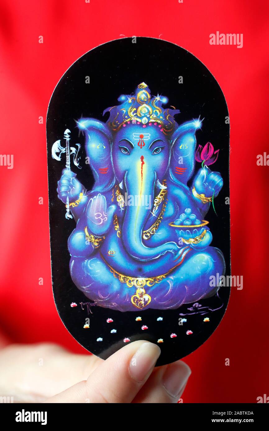 Close-up. Hindu god image in hand. Ganesha also known as Ganapati,  is one of the best-known and most worshipped deities in the Hindu pantheon. Stock Photo