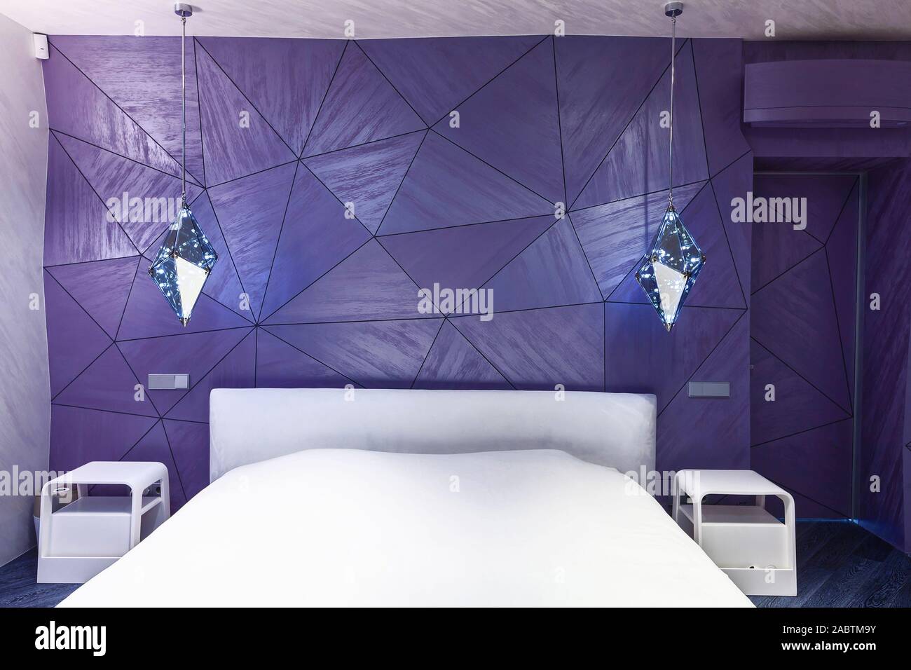 Modern Design In A Bedroom With A Violet Wall With Geometric