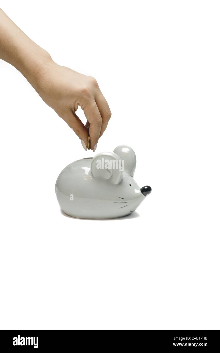 A woman puts a coin in the piggy bank of a gray mouse. Symbol of 2020, family budget and saving money. Stock Photo