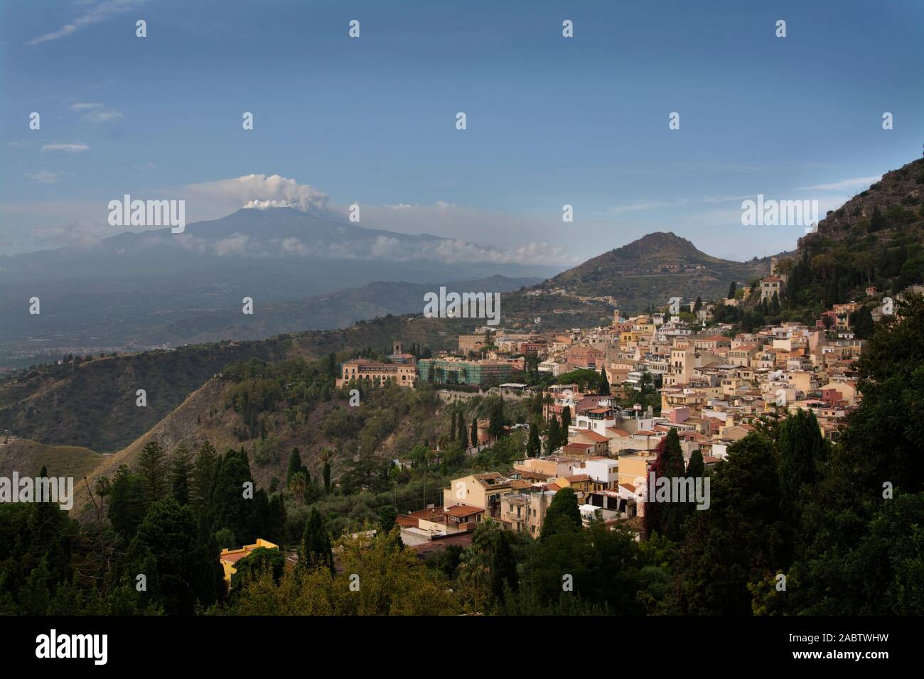 Italy, Sicily, Taormina, town with Mount Etna and steam escaping from crater Stock Photo
