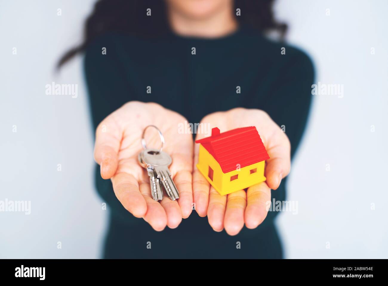 Female hand holding house key, real estate agent Stock Photo - Alamy