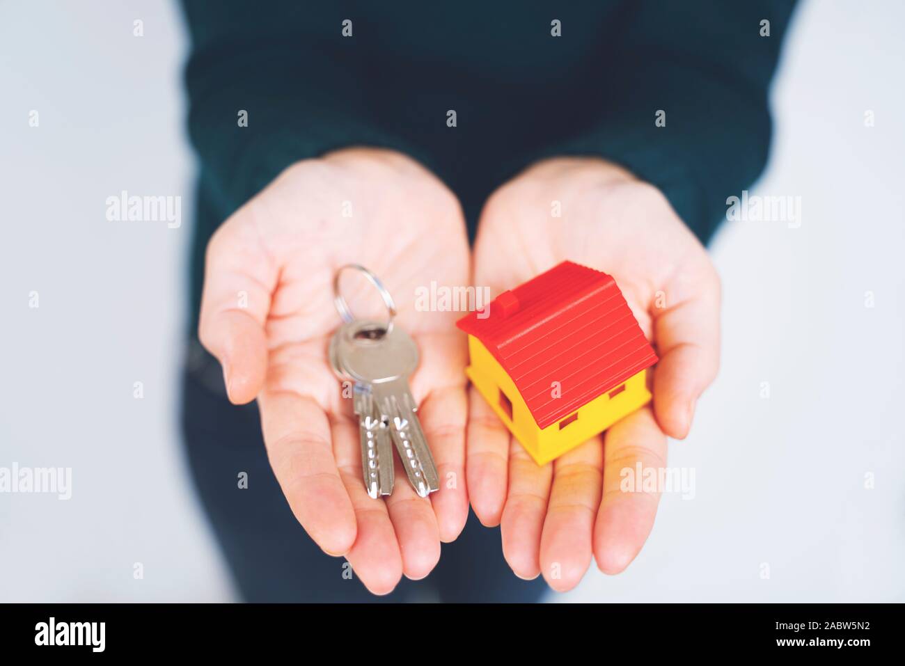 Female hand holding house key, real estate agent. Stock Photo