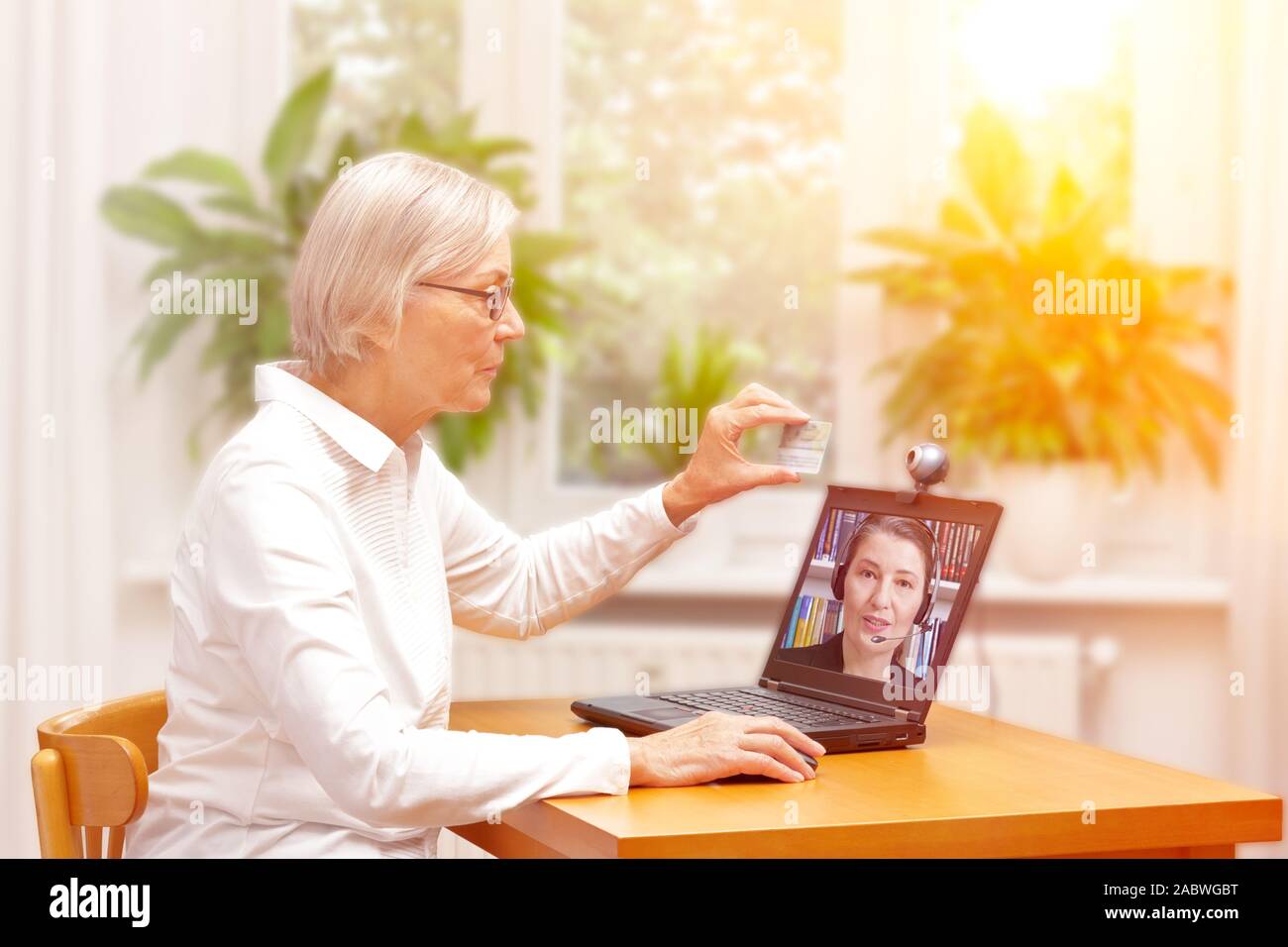 e-id concept: senior woman using a video identification service to open a new bank account with her laptop Stock Photo