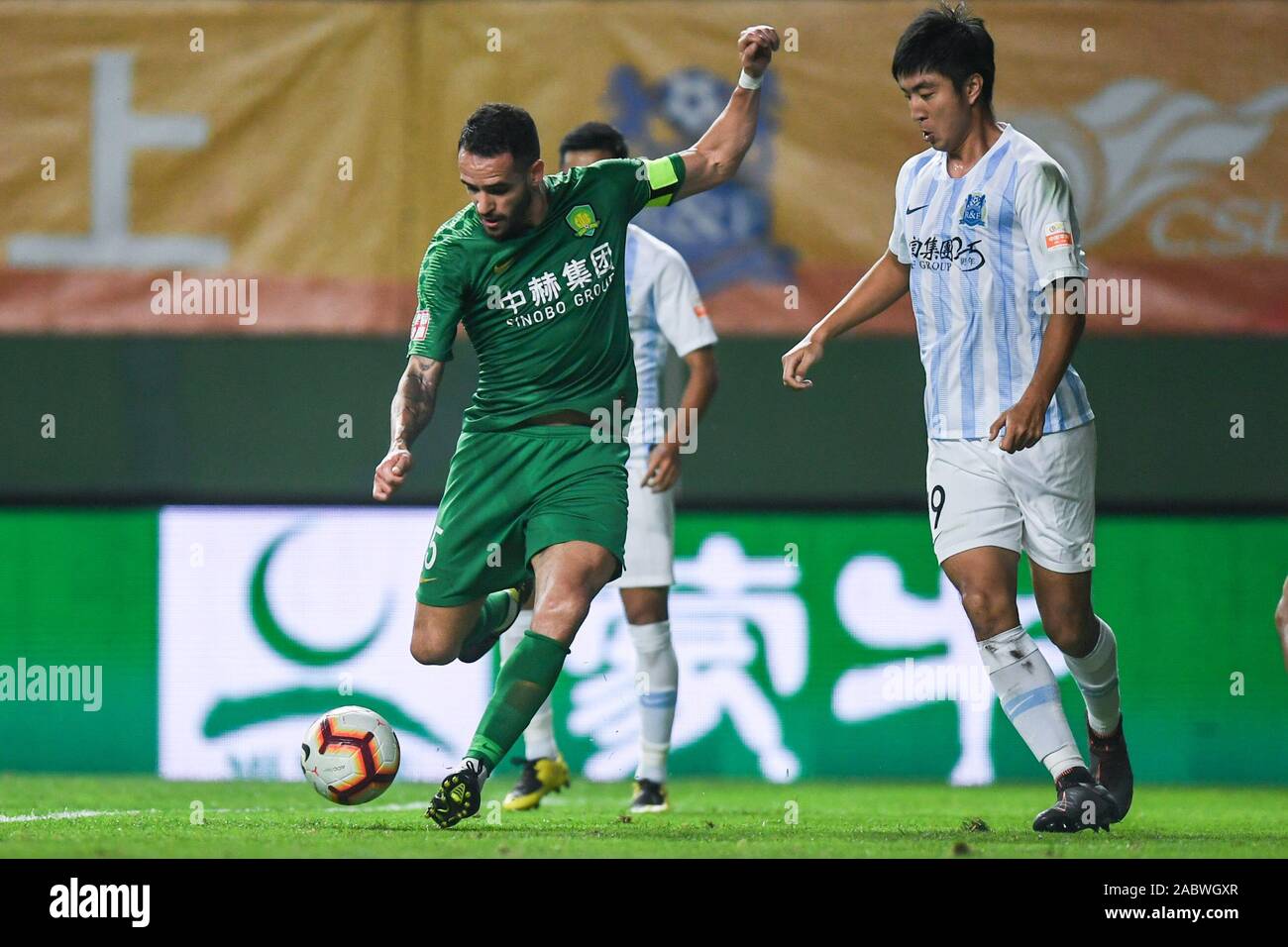 Brazilian football player Renato Soares de Oliveira Augusto, or simply Renato Augusto, of Beijing Sinobo Guoan F.C., left, shoots during the 29th round match of Chinese Football Association Super League (CSL) against Guangzhou R&F in Guangzhou city, south China's Guangdong province, 27 November 2019. Guangzhou R&F slashed by Beijing Sinobo Guoan with 1-4. Stock Photo