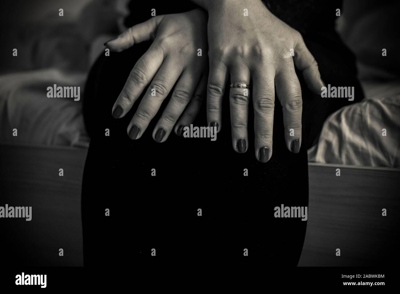 A close-up of a woman with hands on her lap in black and white Stock ...