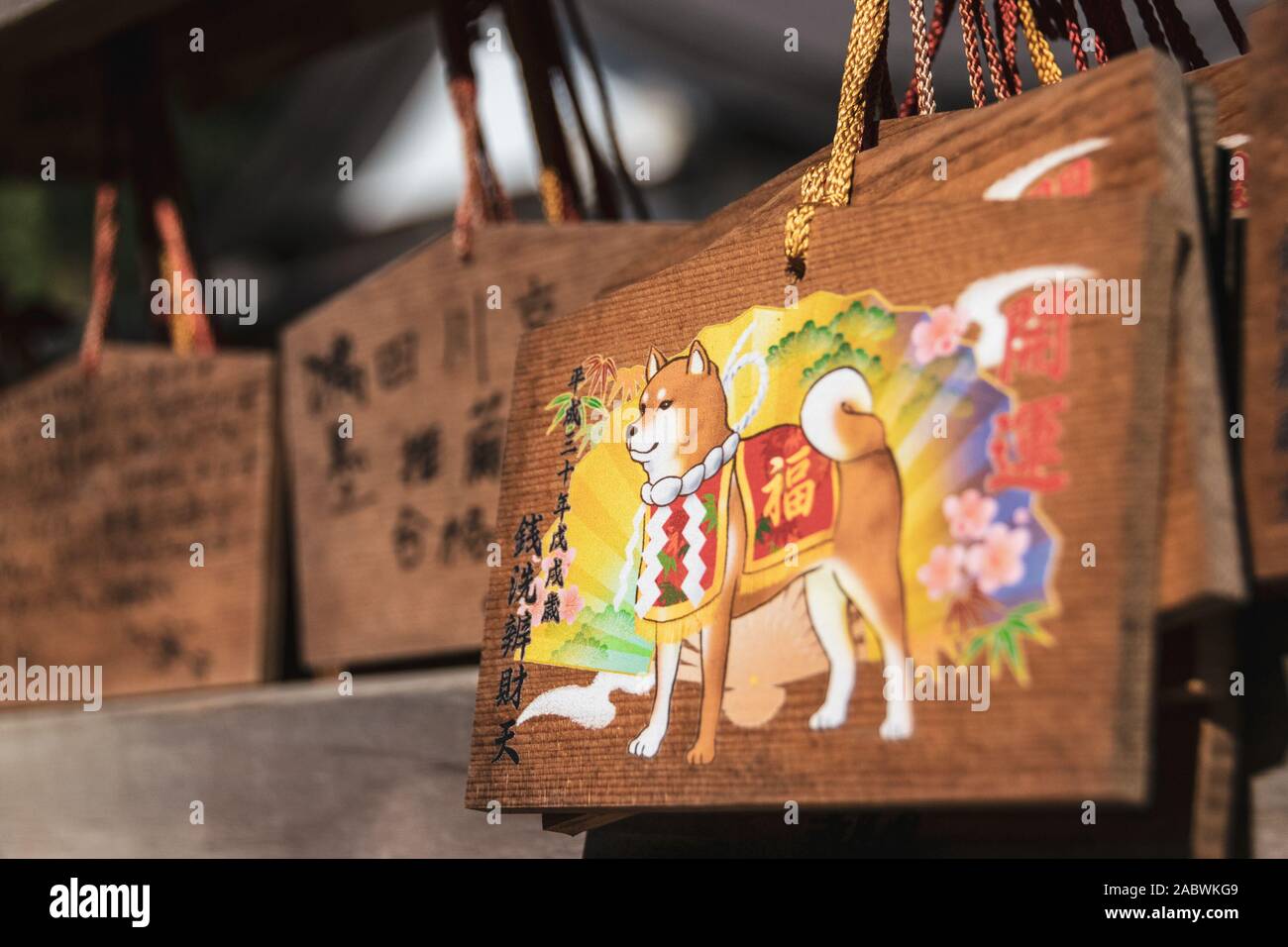 Close-up on a colorful votive plaque depicting a shiba inu dog. 'Ema' plaques are commonly for writing wishes by shinto believers. Stock Photo