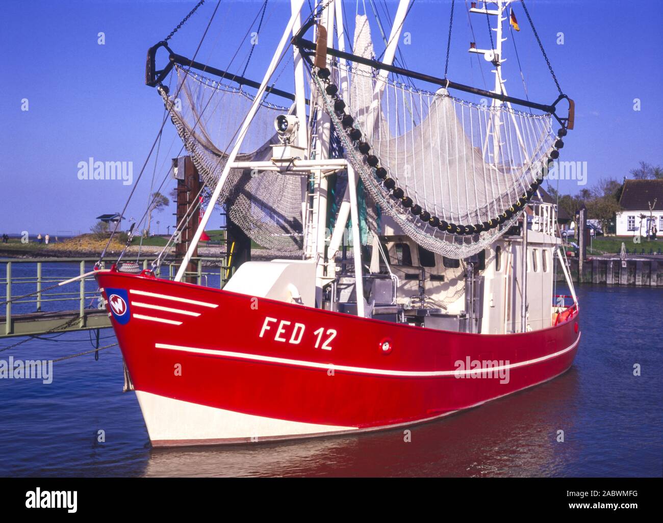 roter krabbenkutter mit hochgezogenem fanggeschirr am anleger in fedderwardersiel Stock Photo