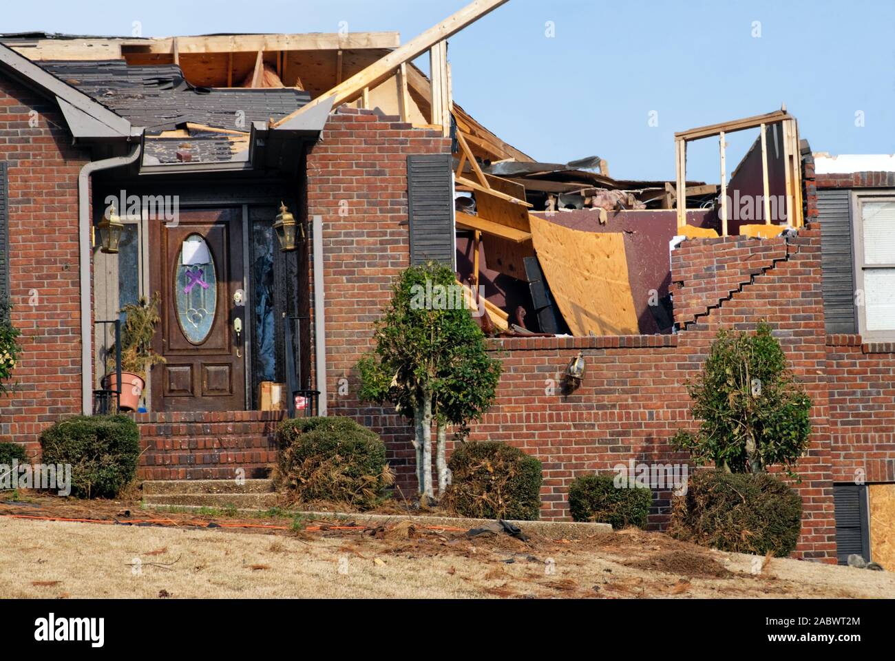 A brick house with no roof after a tornado came through this neighborhood in the springtime. Stock Photo