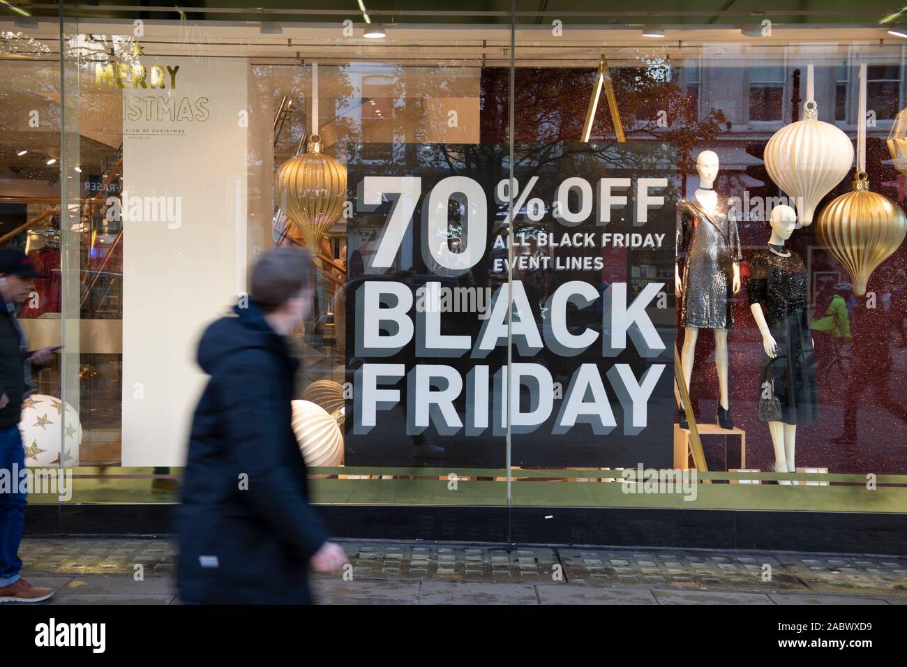 Oxford Street, London, UK. 29th November 2019. Winter sun brings out shoppers looking for Black Friday discounts in Londons premier shopping street. Next store window posters. Credit: Malcolm Park/Alamy Live News. Stock Photo
