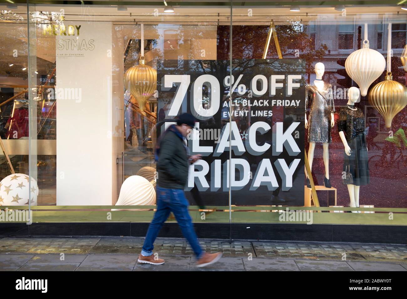 Oxford Street, London, UK. 29th November 2019. Winter sun brings out shoppers looking for Black Friday discounts in Londons premier shopping street. Next store window posters. Credit: Malcolm Park/Alamy Live News. Stock Photo