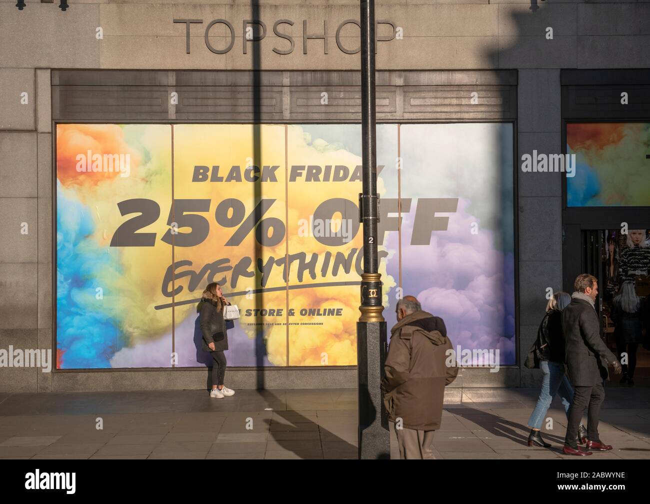 Oxford Street, London, UK. 29th November 2019. Winter sun brings out  shoppers looking for Black Friday discounts in Londons premier shopping  street. Sale posters cover the frontage of Top Shop flagship store