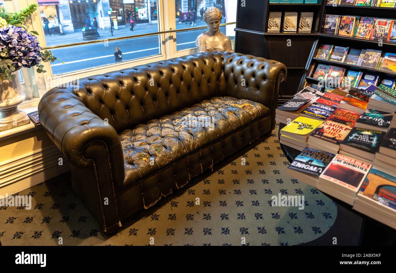 A worn out leather couch for customers, inside Hatchard bookshop, Piccadilly, London, England, UK. Stock Photo