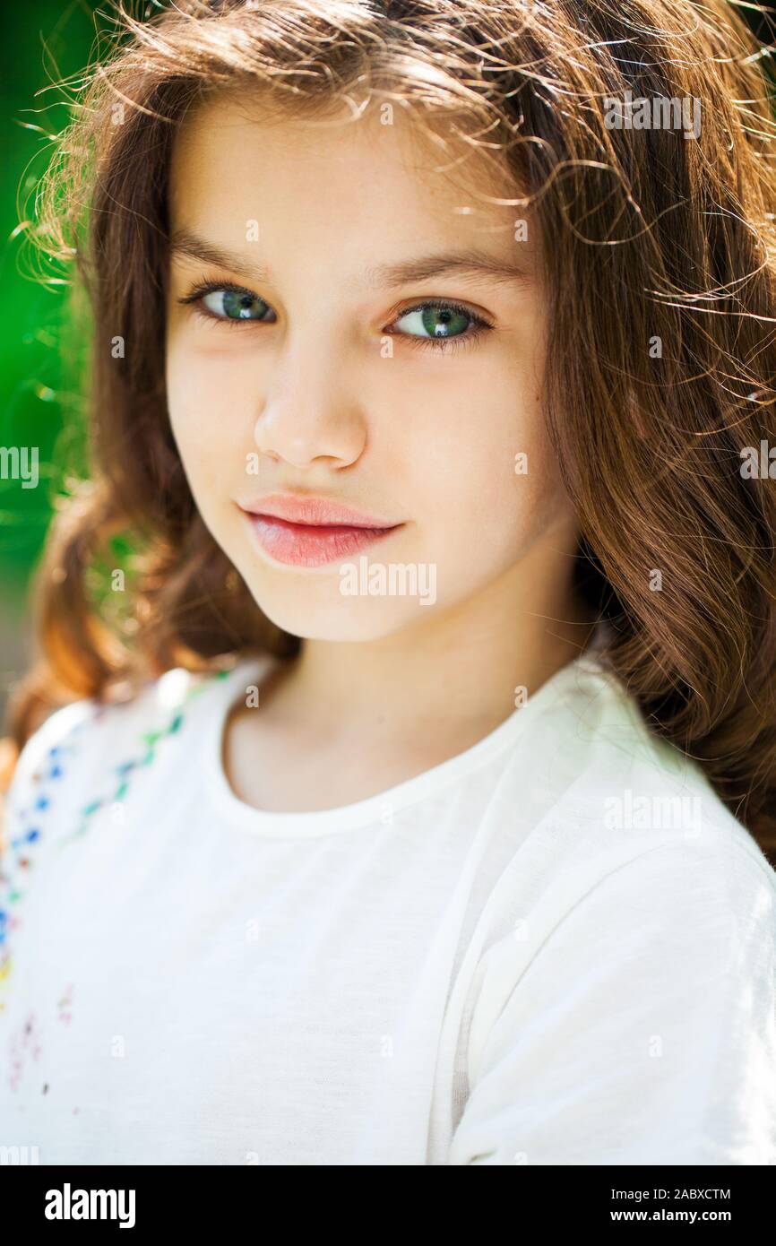 Calm brunette little girl in summer park, outdoor Stock Photo - Alamy