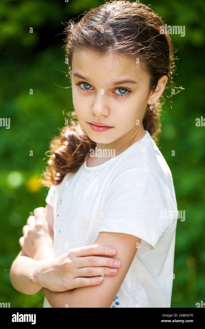 Calm brunette little girl in summer park, outdoor Stock Photo - Alamy