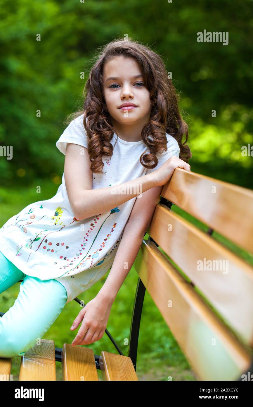 Calm brunette little girl in summer park, outdoor Stock Photo - Alamy