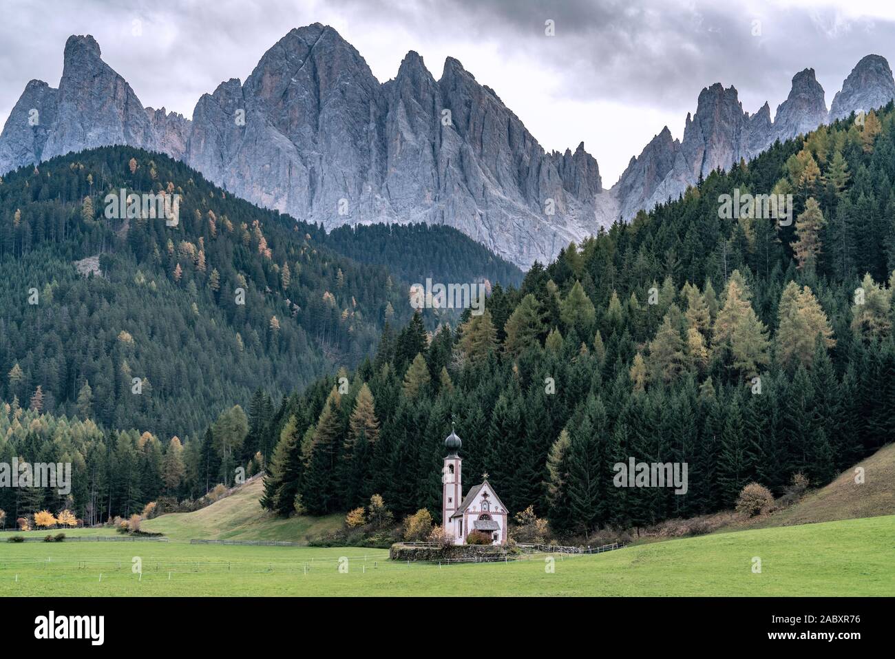 St. Johann in Ranui - a small church with onion tower in front of the Dolomite mountais Geissler massif in Santa Maddalena, Italy Stock Photo