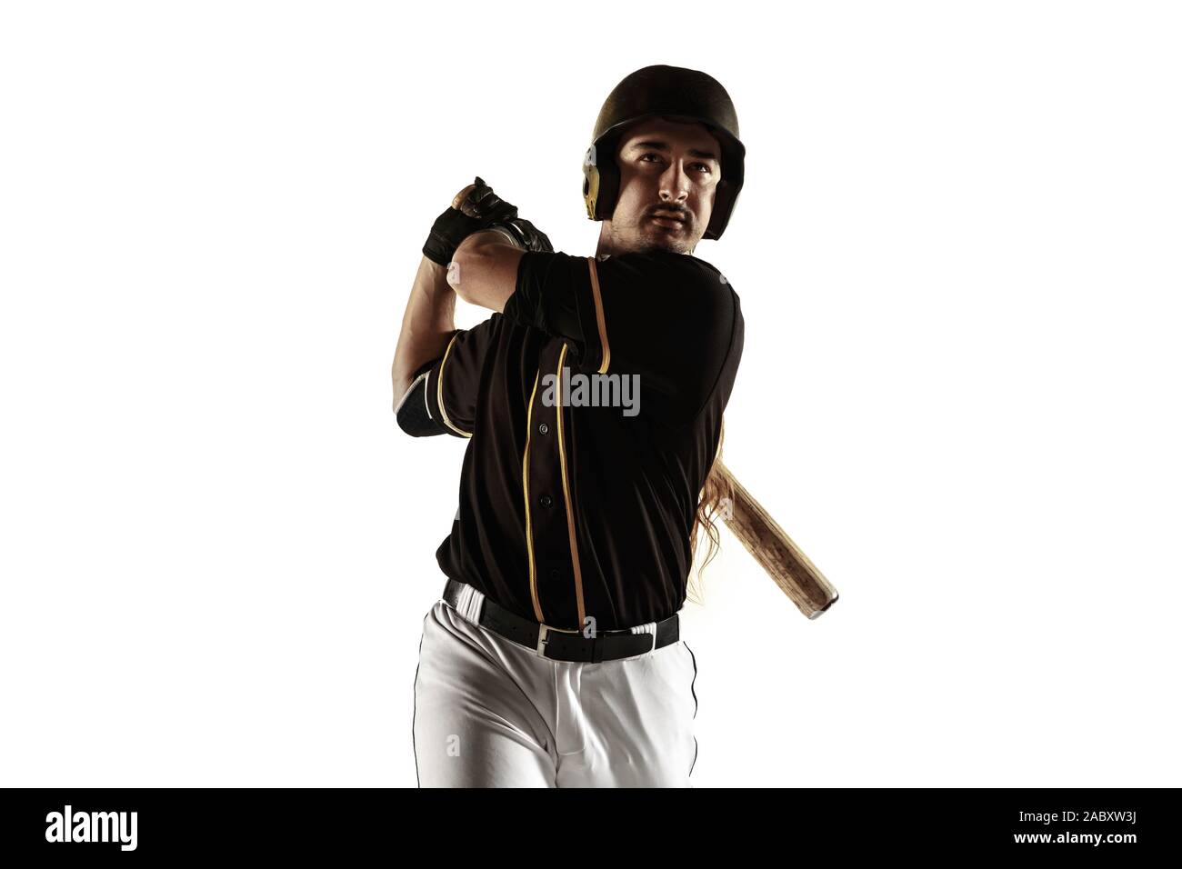 Baseball player, pitcher in a black uniform practicing and training isolated on a white background. Young professional sportsman in action and motion. Healthy lifestyle, sport, movement concept. Stock Photo