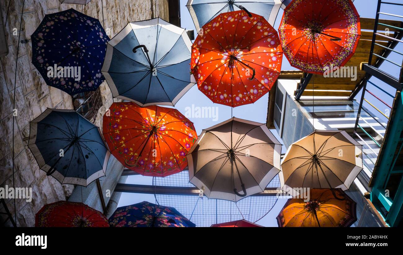 Brightly colored umbrellas offer shade over an Amman staircase. Stock Photo