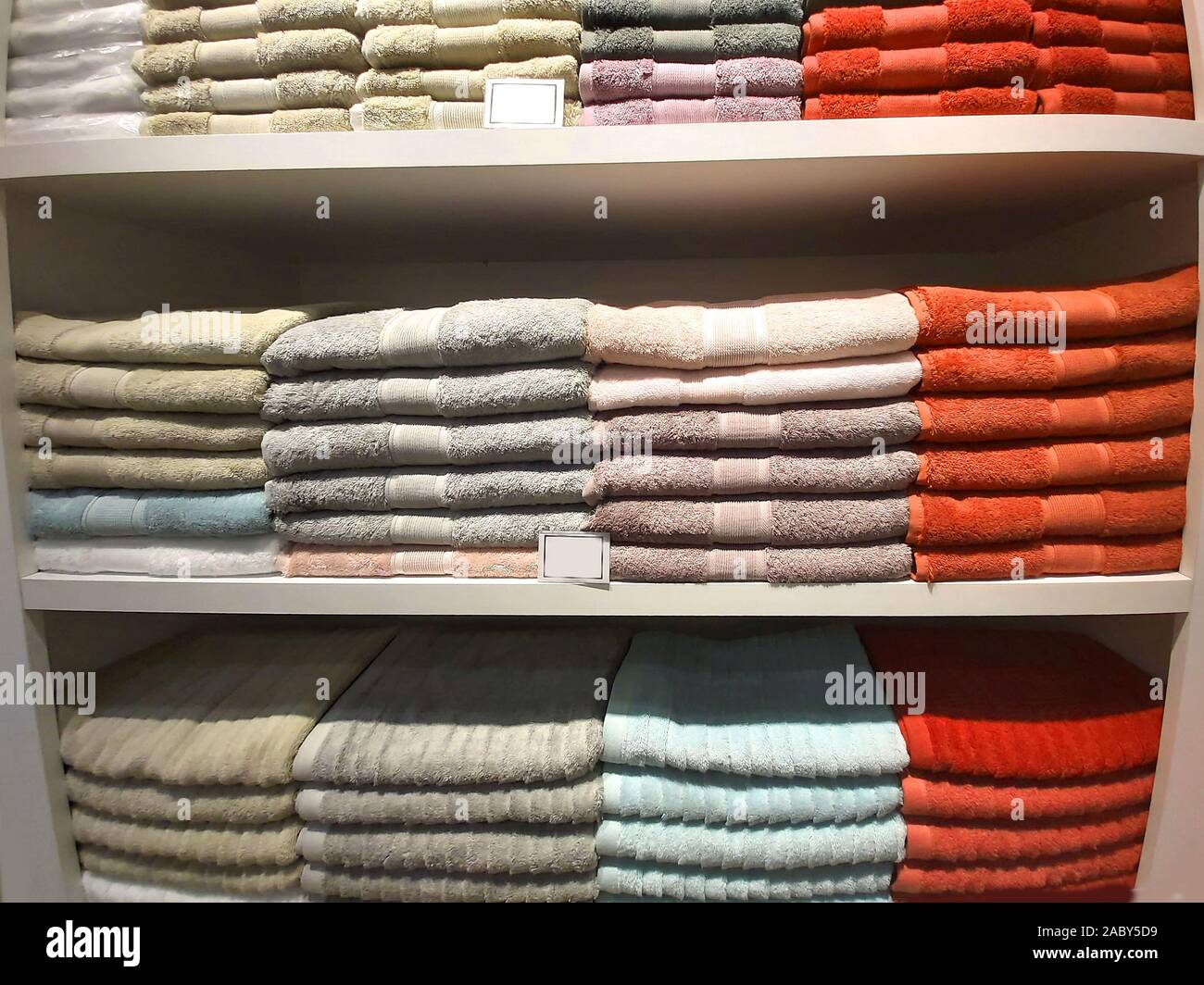 A pile of multi-colored terry towels on a shelf. Stock Photo