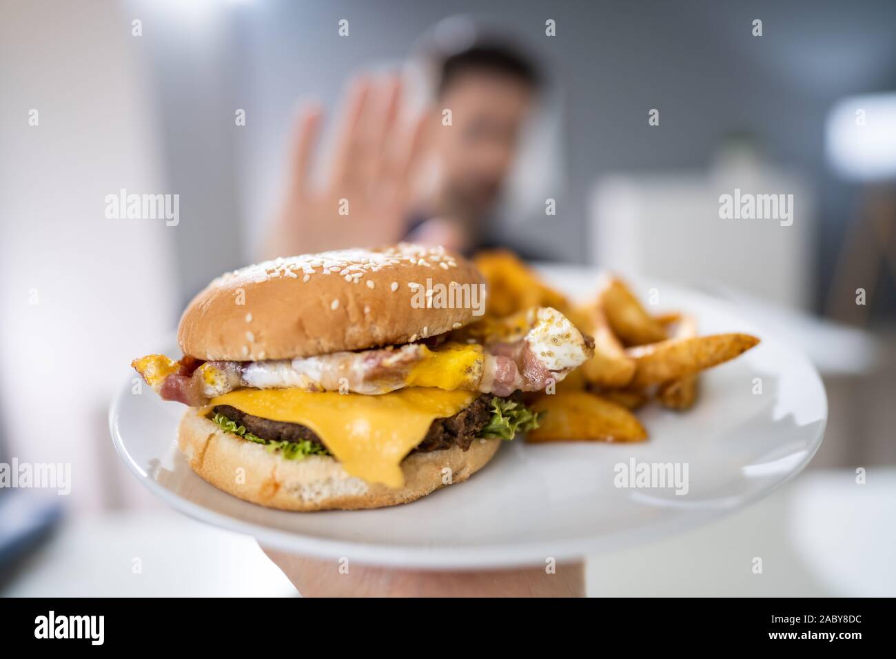 Close-up Of A Man's Hand Refusing Burger Offered By Person Stock Photo